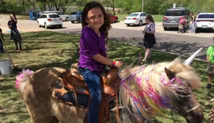 A girl on a horse decorated as a unicorn