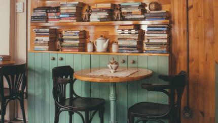 Table and chairs with book shelf behind it