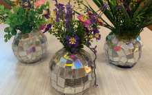 Photograph of three completed disco ball vases with faux flowers.
