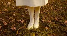 A young stands as she possess in her nice off-white dress shoes A young girl's feet in dress shoes