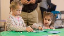 Light Up the Holidays: Stories and Crafts Girls making a craft at a Light Up the Holidays program