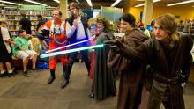 Cosplayers in costume, holding light sabers