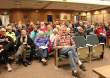Patrons wait for the lecture to begin. Patrons wait for the lecture to begin.