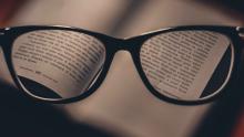 Adult Literacy One-to-One Glasses magnifying the text on the page of a book
