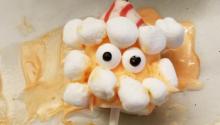 Candy on a stick with marshmallows to look like a face.