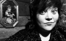 Photo of scary story teller in black and white with spooky background.