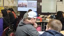 students in classroom with slide projected in background