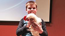 Presenter's son holding chicken at talk about chicken-raising Presenter's son holding chicken at talk about chicken-raising