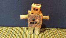A robot sculpture made from cardboard and mixed materials. 