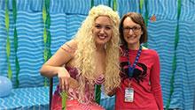 Children's librarian posed with the professional mermaid, smiling toward camera
