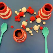 Photograph of red and white cotton balls and green spoons
