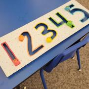 Photograph of a Manipulation Station table with large traceable paper numbers 1 2 3 4 5