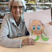 A senior poses with their finished portrait