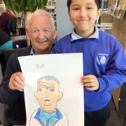 A senior poses with a child artist and their finished portrait