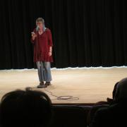A student recites a poem on stage