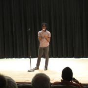 A student recites a poem on stage