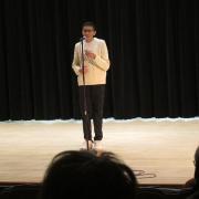 A student recites a poem on stage