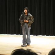 A student recites a poem on stage