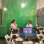 People recording the World on the Move podcast in a recording studio in front of a green screen