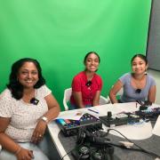 People recording the World on the Move podcast in a recording studio in front of a green screen