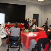 People sitting at tables looking at a slideshow on Jane Austen.