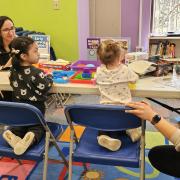 Two toddlers play at a table