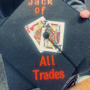 Grad cap decorated with two playing cards and text "A Jack of All Trades"