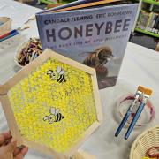 A honeycomb craft made of popsicle sticks and bubble wrap with the book "Honeybee"