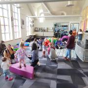 Babies and their caregivers dance around the Baby Rave room