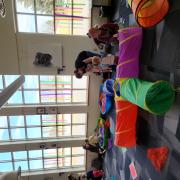 Babies and their caregivers dance around the Baby Rave room