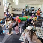 Babies and their caregivers dance around the Baby Rave room
