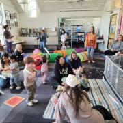 Babies and their caregivers dance around the Baby Rave room