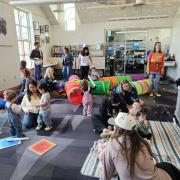 Babies and their caregivers dance around the Baby Rave room