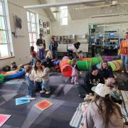 Babies and their caregivers dance around the Baby Rave room