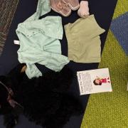 A photograph of  a dress the Teddy station with a teddy bear and clothing.