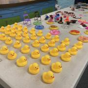 Rubber duckies lined up on a table with other small objects for decoration