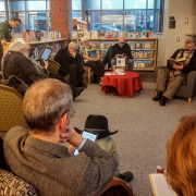 Photograph of participants sitting in a circle reading "A Christmas Carol" together