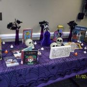 Traditional ofrenda or altar was made with books about Day of the Dead, tea lights, and wooden decorations