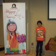 Child poses with Nowruz banner