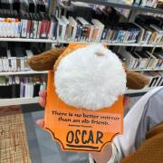 Photograph of finished stuffed animal taxidermy board. Text on the orange board reads: "There is no better mirror than an old friend" with the name Oscar written below.