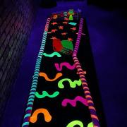 Photograph of Glow Golf hole lit up in neon colors under blacklights