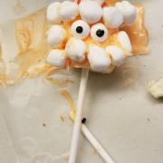 Candy on a stick with marshmallows to look like a face.