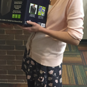 Photograph of library staff member smiling and holding a paper shredder.