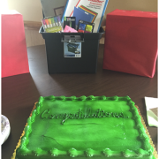 Photograph of graduation cake. The cake is green and has "Congratulations" written in green icing.