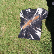 A painted t-shirt laying on grass