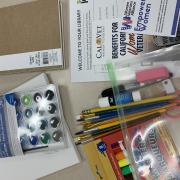 Photograph of the art supply kit shows markers, water color pain set, pencils and paper.