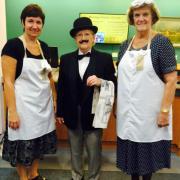 Three people, two in aprons, one in a suit 