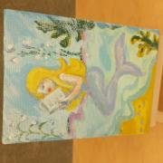 Photo of art canvas with painting of mermaid reading a book