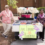 Two people standing next to decorated golf cart