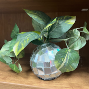 Photograph of a completed disco ball vases with a faux green plant.
